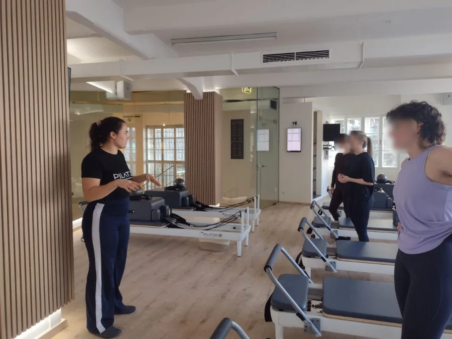 Eleni teaching a Pilates reformer session in a Vienna studio