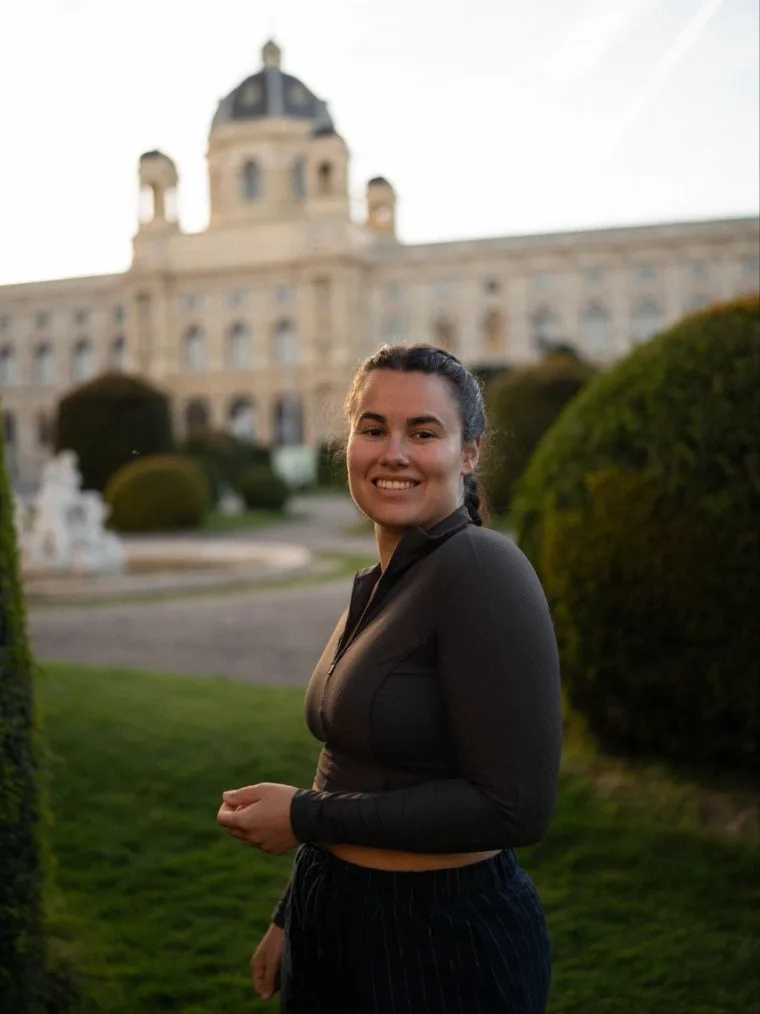 Eleni standing in the museum gardens in Vienna, ready for a one-to-one session